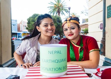 Volunteers beside a Nepal earthquake donation box at a Perth street stall
