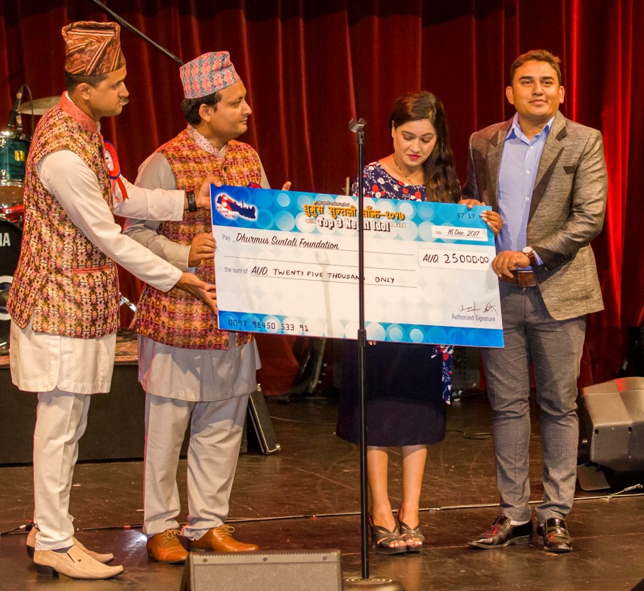 We Care Nepal presenting a cheque for AUD 25,000 to the Dhurmus Suntali Foundation on stage
